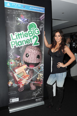 JWoww posing next to LittleBigPlanet 2